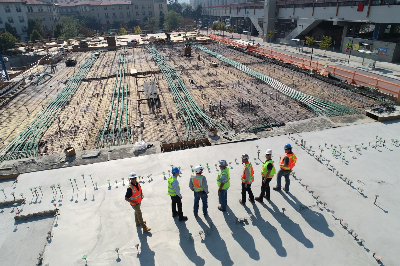 Construction crew reviewing work on a large project site, seen from above